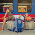 Male backpacker tourist napping on a bench